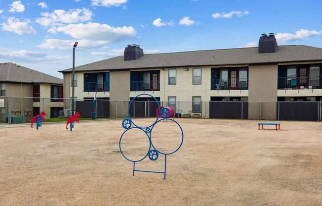 Dog park in front of apartment buildings at Heritage Square apartments.