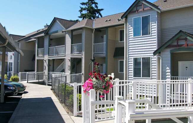 A white picket fence with a bench and flowers on it.