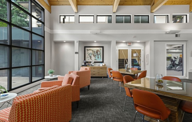 A room with orange chairs and a wooden ceiling.