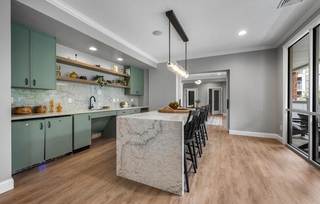 Entertainment kitchen with a stone-inspired island, open shelving, and bar seating, creating a stylish setting for gatherings, celebrations, and shared experiences.