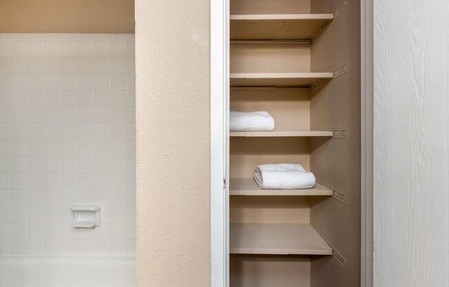 a bathroom with a closet with white towels