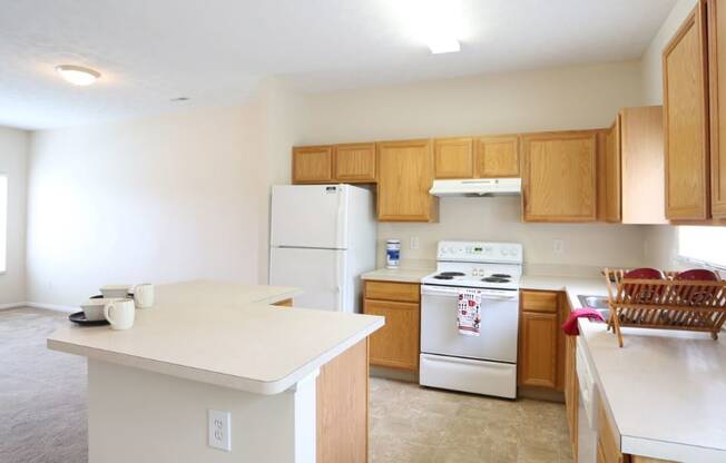 a kitchen with white appliances and wooden cabinets
