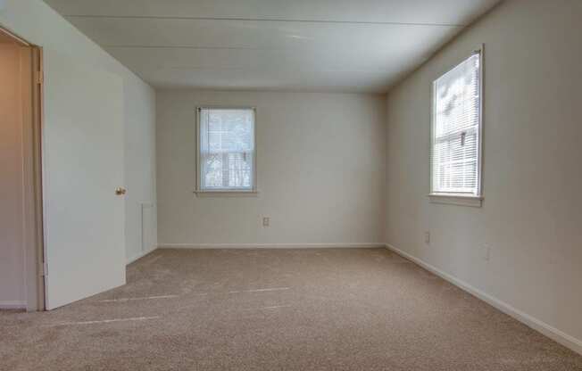 Large bedroom with high ceilings and two large windows