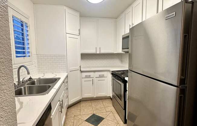 a kitchen with stainless steel appliances and white cabinets