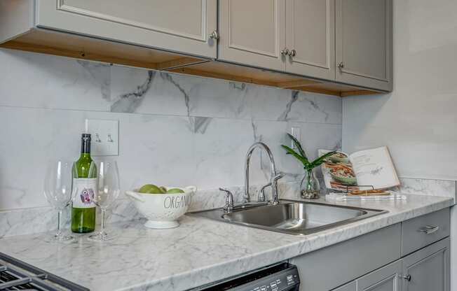 a kitchen counter with a sink and a bottle of wine on it