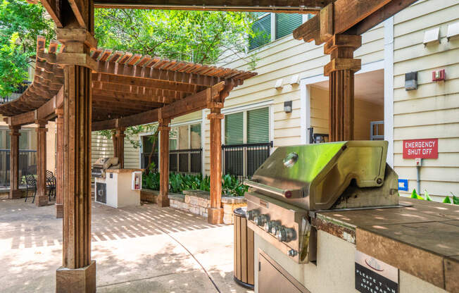 a backyard with a barbecue grill and a pergola