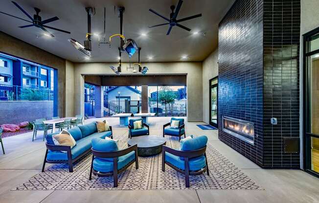 a lobby with blue chairs and couches and a fireplace