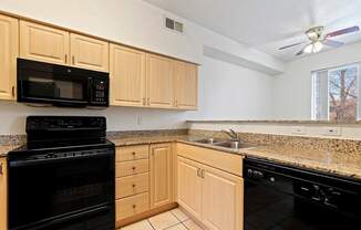 A kitchen with black appliances and wooden cabinets.