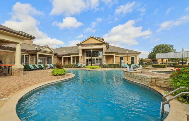 A large swimming pool in front of a house.