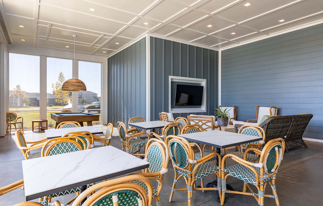 a patio with tables and chairs and a television