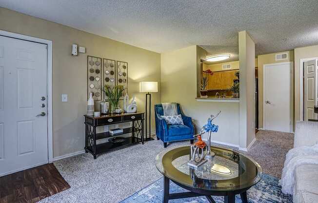 A living room with a blue chair and a coffee table.