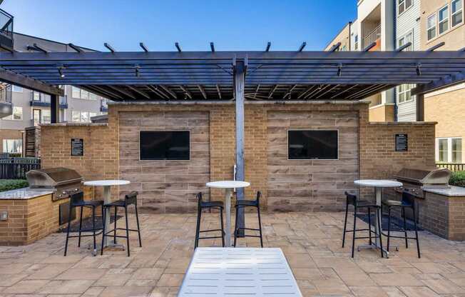 A patio with a table and chairs under a roof.