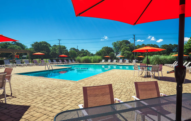 a swimming pool with umbrellas and chairs around it