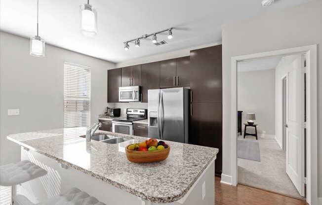 a kitchen with a granite counter top and a stainless steel refrigerator