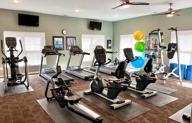 a spacious fitness room with treadmills and other exercise equipment