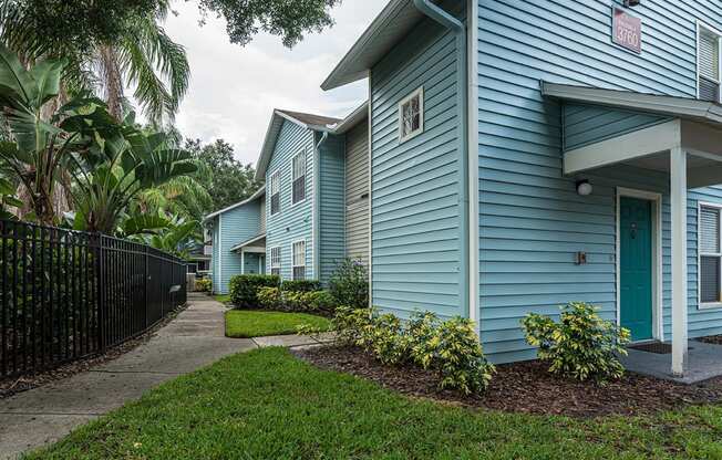 a blue house with a sidewalk in front of it