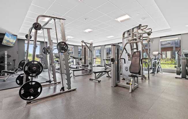 A gym with a variety of equipment including weight machines and free weights.