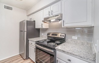 a kitchen with white cabinets and a stainless steel refrigerator