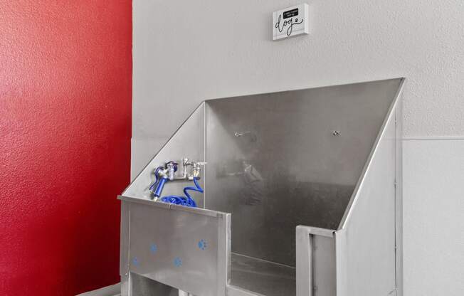 a stainless steel bathroom with a sink and a red wall at Verona, Colorado, 80123