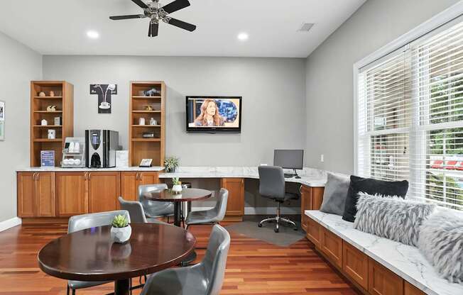 A living room with a brown table and grey chairs.