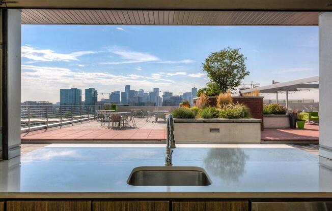 a view of the city from a rooftop deck with a sink