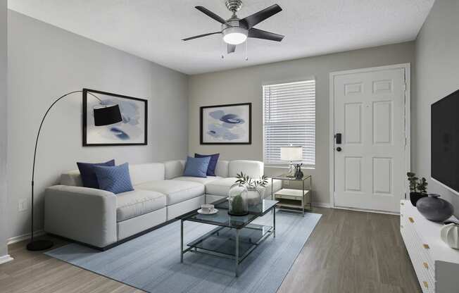 a living room with a white couch and a ceiling fan