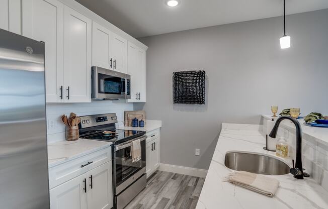a kitchen with white cabinets and stainless steel appliances