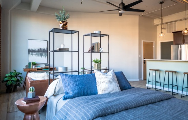 a bedroom with a bed and a kitchen in the background at The 22 Apartments, St. Louis, 63103