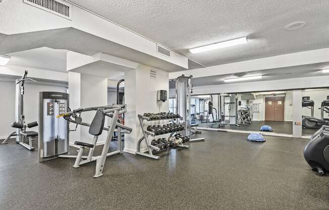 a gym with exercise equipment and weights on the floor
