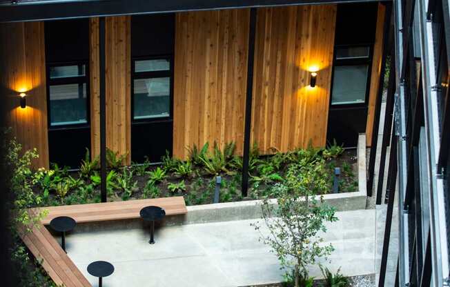 a courtyard with benches and plants in front of a building