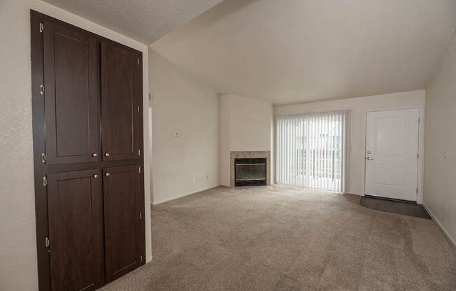 A room with a fireplace and a door on the right at Pepperwood Apartments, California, 95661