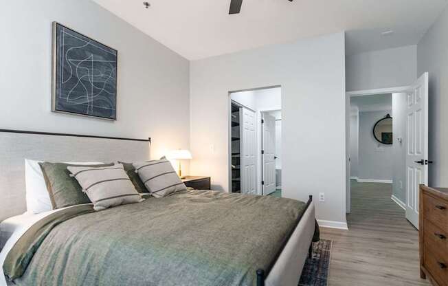 A bedroom with a bed, nightstands, and a painting on the wall.