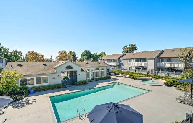 the view of a swimming pool with apartments in the background