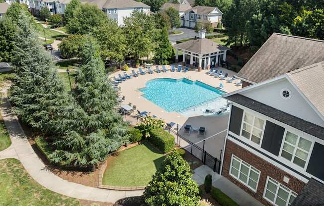 A large swimming pool surrounded by a grassy area and trees.