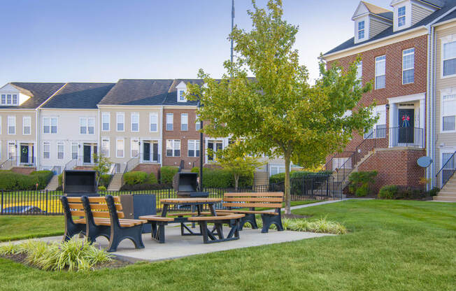 a patio with benches and a table in front of a building