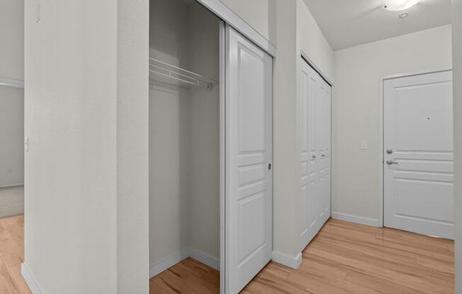 a bedroom with two closets and a hard wood floor