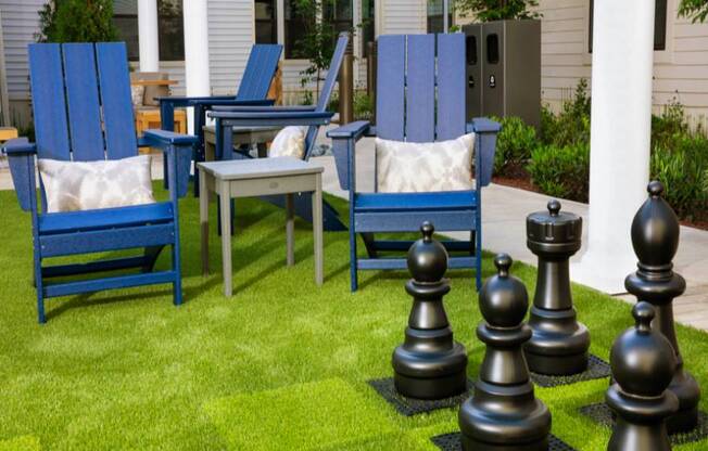 A set of chess pieces are set up on a lawn.