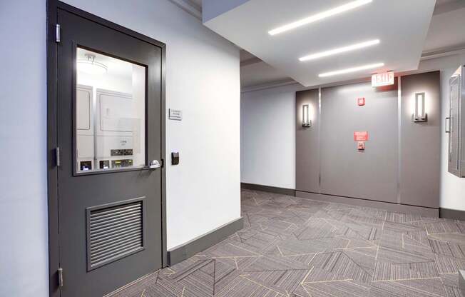 A hallway with a black door and a grey door.