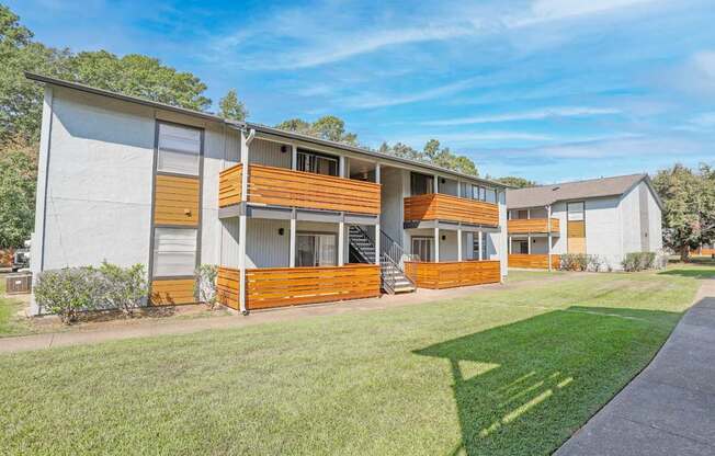 A modern two-story apartment building with a white exterior and wooden accents at The Marq apartments in Shreveport, LA