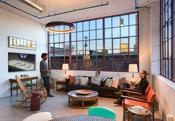 Steelcote Lofts clubroom with conversational seating, TV and oversized windows  at Steelcote Square, St. Louis, MO