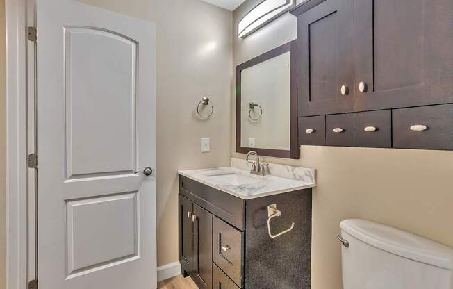 A bathroom with a white sink and a white toilet.