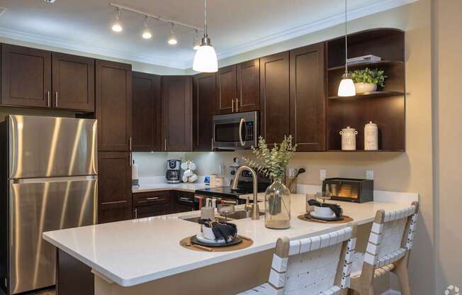 A kitchen with a white countertop and dark brown cabinets.