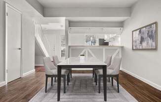 A dining room with a table and chairs.