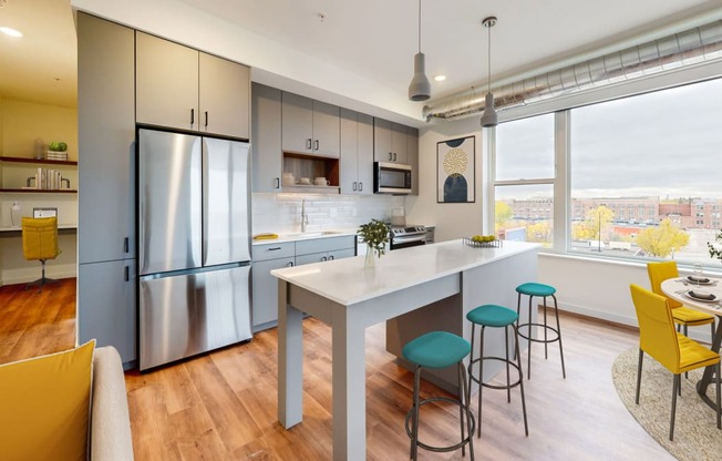 a kitchen with a large window and a table with chairs