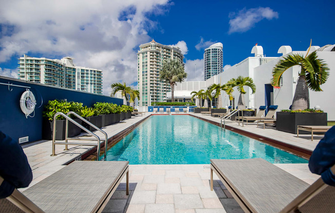a swimming pool at a hotel with skyscrapers in the background