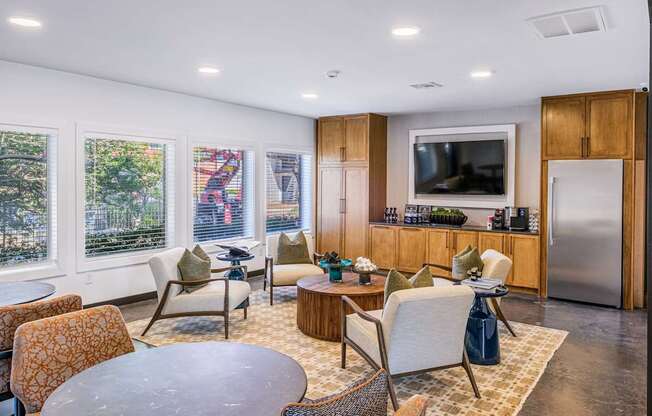 A modern living room with a television, a kitchen area, and a dining table.