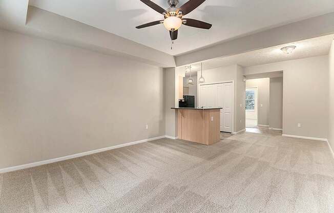 A living and dining room with a ceiling fan and a carpeted floor at Lynbrook Apartments and Townhomes, Elkhorn, NE, 68022