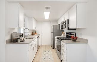 a kitchen with white cabinets and stainless steel appliances