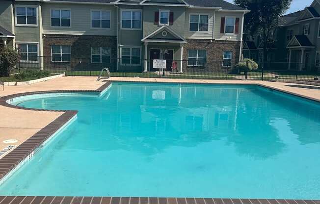 a large swimming pool with an apartment building in the background