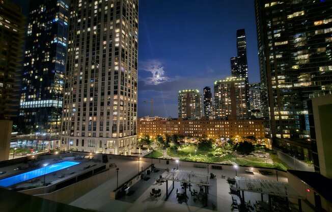 a view of the city at night from a rooftop terrace